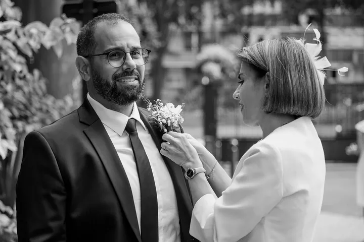 La maman du marié épingle la boutonnière pendant les préparatifs