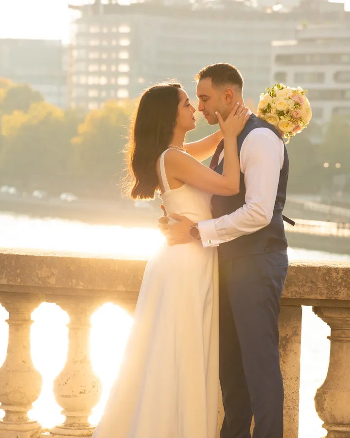 Couple enlacé au coucher du soleil sur un pont de Paris